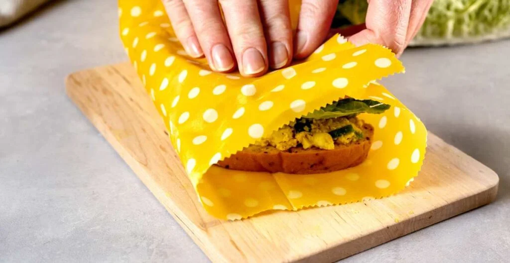Foto de uno de los envoltorios de cera de abeja de ecomuna envolviendo un sandwich